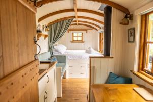 a small kitchen with a bed in a tiny house at Camp de Rêves Glampsite in St Peter