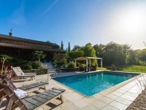 einen Pool mit zwei Stühlen und einem Pavillon in der Unterkunft Poolside Haven in Salles in Larzac