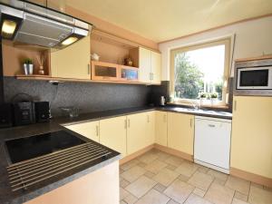 a kitchen with white cabinets and a window at Villa in Bruinisse near Grevelingenmeer in Bruinisse