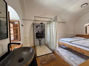 a bathroom with a sink and a bed and a tub at Stadtjuwel am Neusiedlersee in Rust