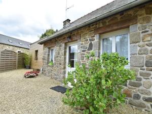 a stone house with a window and a bush at Holiday Home Saint-Gilles near Beach in Saint-Gilles-les-Bois