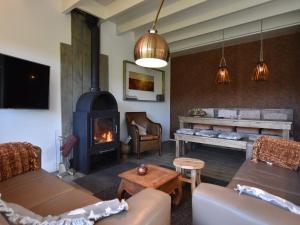 a living room with a couch and a fireplace at Holiday Home in Reutum with Bubble Bath in Beekdorp +32 photos