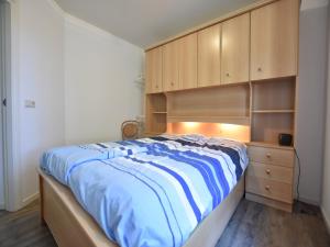 a bedroom with a bed and wooden cabinets at Holiday Home in Reutum with Bubble Bath in Beekdorp