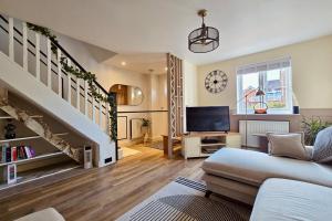 a living room with a couch and a tv at Newbury Garden Retreat in Headley