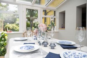 una mesa blanca con platos y vasos azules y blancos en Cosy City-Centre House near Train Station & Business School, with Garden, en Oxford
