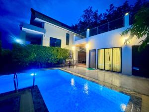 a swimming pool in front of a house at night at Beewell Villa Aonang in Ao Nang 