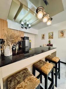 - une cuisine avec un bar avec deux tabourets dans l'établissement Avida Towers San Lazaro, à Manille