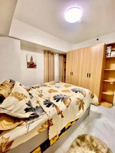 une chambre avec un lit avec une couette fleurie dans l'établissement Avida Towers San Lazaro, à Manille