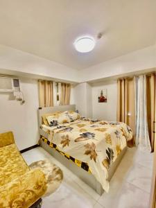 une chambre avec un lit et une chaise dans l'établissement Avida Towers San Lazaro, à Manille 2 autres photos