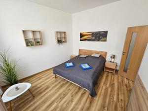 a bedroom with a bed with two blue folders at GUDU apartments in Košice