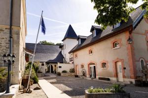 a row of buildings with a flag in a street at Château de Saint-Genix in Saint-Genix-sur-Guiers