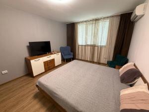 een kleine slaapkamer met een bed en een televisie bij Alex Family Apartment in Vidin