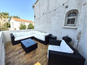 un patio con sofás y una mesa en un edificio en Chez nous, en Lucciana