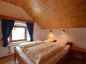 a bed in a room with a wooden ceiling at Holiday home in Butgenbach near the Lake in Butgenbach +31 photos