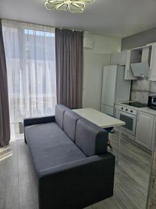 a living room with a couch and a table in a kitchen at Nyvky Like Home - Файна Таун із сезонним басейном - Кв 6 низький поверх in Kyiv