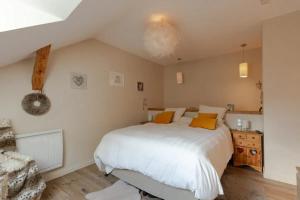 a bedroom with a large white bed with orange pillows at Maison chaleureuse à Faverges Seythenex avec terrasse in Vésonne