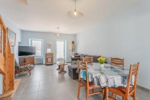 a living room with a table and a couch at La Maison de Retz - 400m centre - Jardin in Bourgneuf-en-Retz