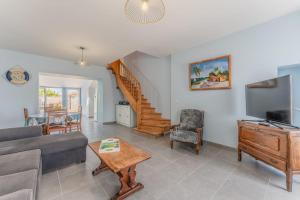 a living room with a couch and a tv at La Maison de Retz - 400m centre - Jardin in Bourgneuf-en-Retz +16 photos