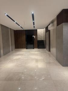 Habitación vacía con suelo de baldosa y escalera. en Milaf lodge1, en Yeda