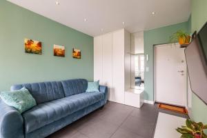 a living room with a blue couch in a room at D&M Apart Lipowa 12 in Białystok