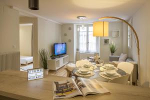 a living room with a table with a newspaper on it at Les Gites Du Retable in Colmar +13 photos
