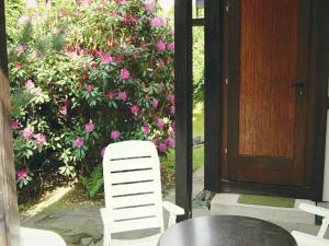 a table and chairs in front of a door with pink flowers at Furnished Bungalow With Peaceful Neighbourhood in Meschede +32 photos