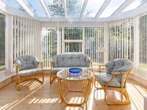 a conservatory with two chairs and a glass table at 4 star holiday home in Højslev in Højslev