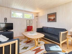 a living room with a couch and a table at 4 star holiday home in Højslev in Højslev