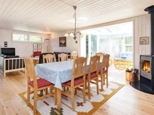 a dining room with a table and chairs and a fireplace at 4 star holiday home in Højslev in Højslev