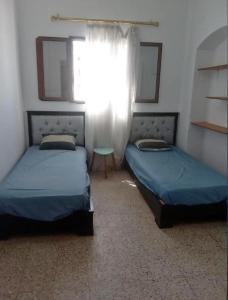 Ένα ή περισσότερα κρεβάτια σε δωμάτιο στο maison sliman plage