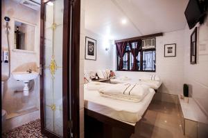 bagno con 2 letti e lavandino di Sun Guest House a Hong Kong