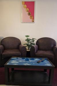 ein Wohnzimmer mit zwei Stühlen und einem Couchtisch in der Unterkunft Parisien Studio in Rabat
