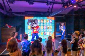 a group of children watching a mickey mouse on a stage at Jen's Retreat in Lossiemouth +9 photos