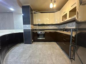 a kitchen with brown cabinets and a stove top oven at comfort home in Itʼkhvisi