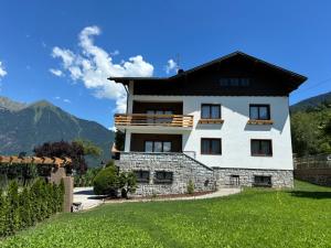 ein großes weißes Haus mit schwarzem Dach in der Unterkunft Mountain Garden Apartments Larice in Giustino