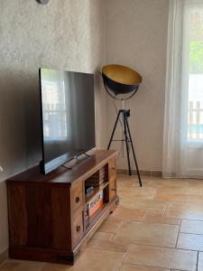 a flat screen tv sitting on top of a wooden entertainment center at Villa avec piscine privée entre terre, ville et mer in Sauvian