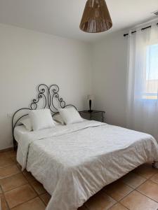 a bedroom with a large bed with a white comforter at Villa avec piscine privée entre terre, ville et mer in Sauvian +17 photos
