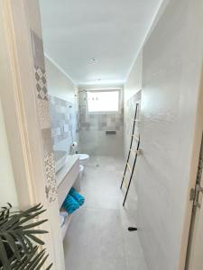 Un baño blanco con inodoro y lavabo. en Margarita 102 Private Beach Access Aqua Esmeralda Dominicus, en La Laguna