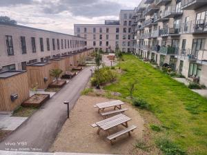 a row of benches in a street with buildings at Nordic Sleep Spot in Glostrup