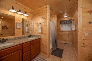 a log cabin bathroom with two sinks and a shower at Always Dreaming by American Patriot Getaways in Hatchertown +35 photos