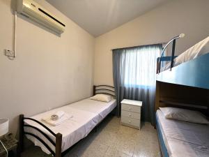 two beds in a small room with a window at STAY Pervolia Maisonette in Sophtadhes