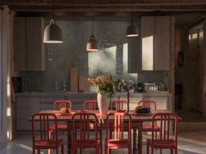 a kitchen with a table with chairs and a vase of flowers at Retreat Near Siorac-en-Périgord in Saint-Germain-de-Belvès