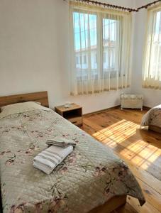 a bedroom with a bed with two towels on it at Къща за гости Странджа in Malko Tŭrnovo