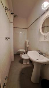a bathroom with two toilets and a sink and a mirror at Albergo ALBERTA in Massa