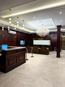 Un gran vestíbulo con una lámpara de araña y una mesa. en راحتي هنا 7, en Riad