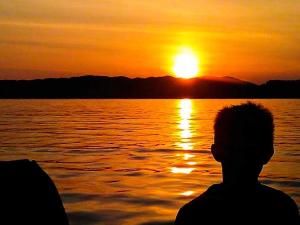una persona sentada en un barco mirando la puesta de sol en 4 person holiday home in Reksteren-By Traum, en Klinkholmen 36 fotos más