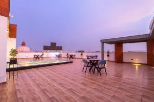 a large deck with a table and chairs on a building at Hotel Limon Sector 45 Gurgaon in Gurgaon