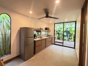 a kitchen with a refrigerator and a large window at Villa Pecho Amarillo in Fortuna