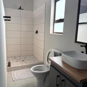 a white bathroom with a toilet and a sink at Cozy NooK Mariental in Mariental +19 photos