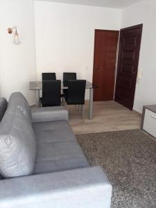 uma sala de estar com um sofá e uma mesa com cadeiras em Apartamento Madalena em Carvoeiro